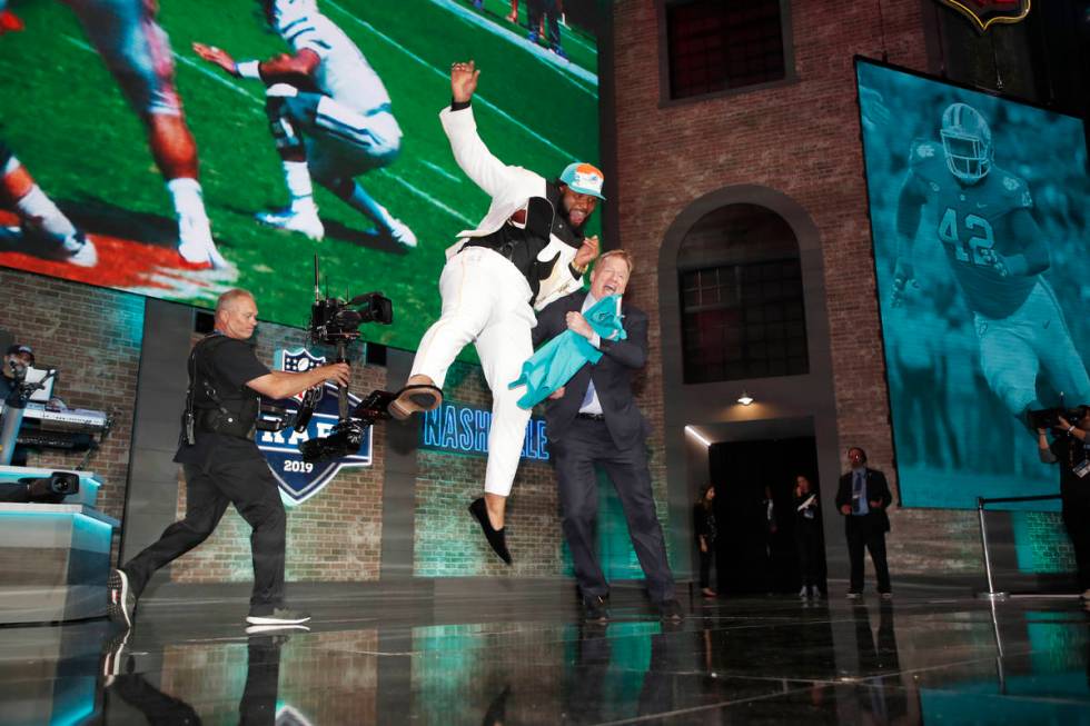 Clemson defensive tackle Christian Wilkins leaps into NFL Commissioner Roger Goodell after the ...