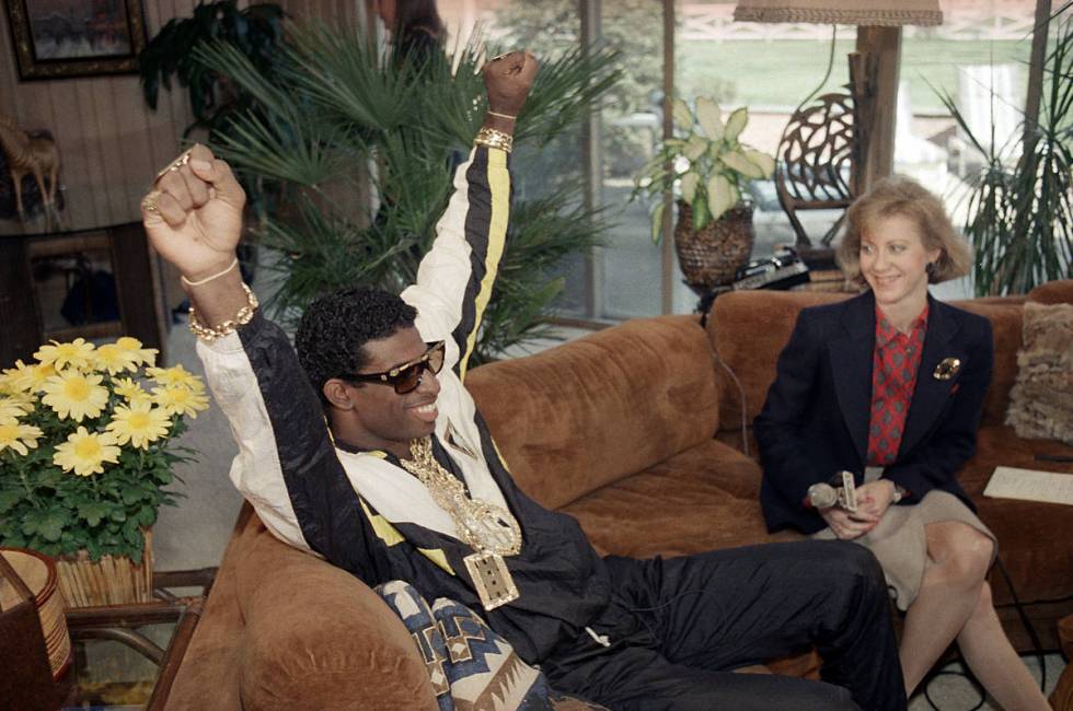 Florida State's Deion Sanders, left, reacts as he sits with television reporter Andrea Kremer, ...