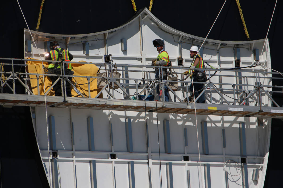 Workers install the Raiders logo at the new practice facility and headquarters in Henderson, We ...