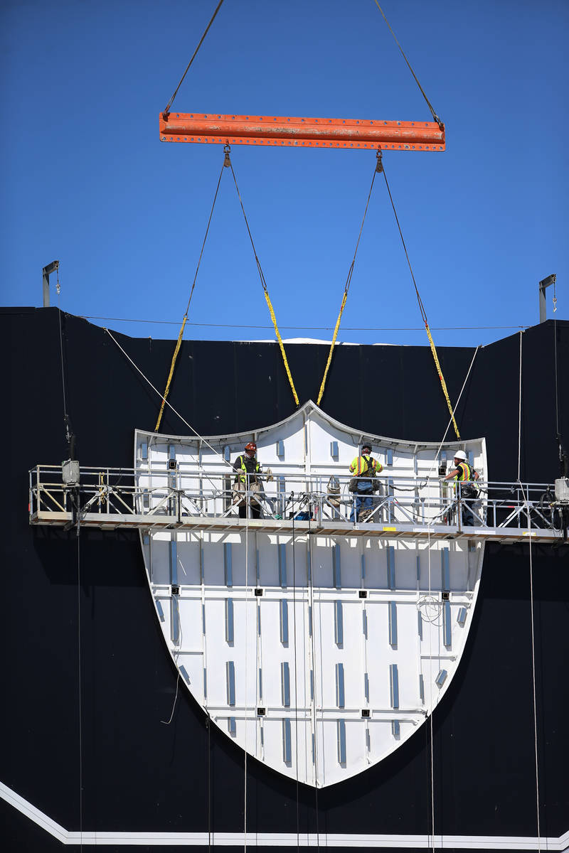 Workers install the Raiders logo at the new practice facility and headquarters in Henderson, We ...