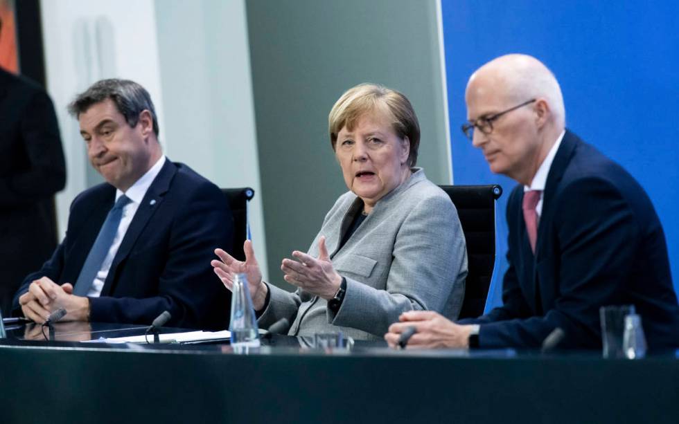 Markus Soder, Prime Minister of Bavaria, left, Germany's Chancellor Angela Merkel, center, and ...