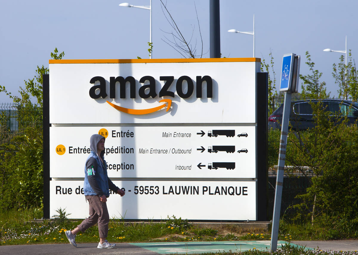 A man walks at the entrance of Amazon, in Douai, northern France, Thursday April 16, 2020. Amaz ...