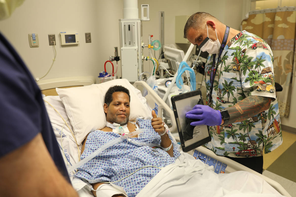 Former Marine Pvt. Ronald Pipkins' VA social worker former Army Sgt. Jim Powers holds up an iPa ...