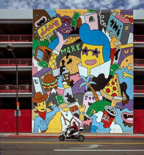 A scooter rider moves along E. Carson Avenue in Downtown Las Vegas during the novel coronavirus ...