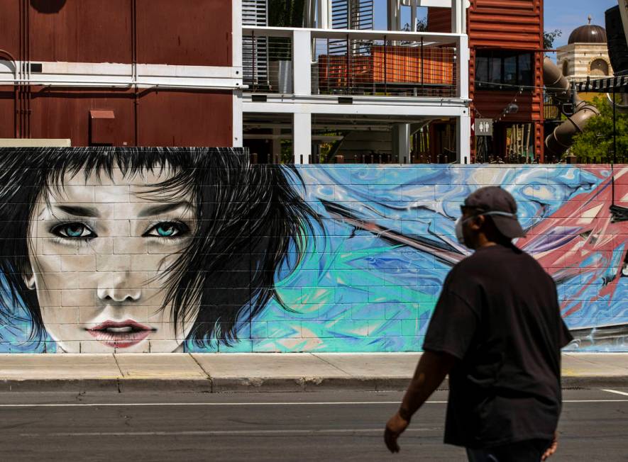A pedestrian walks about a mural on the backside of Container Park along E. Carson Avenue in Do ...