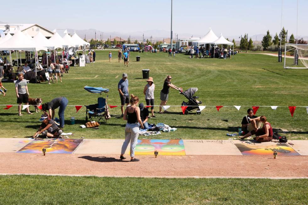 Participants works on their chalk art in part of Chalk and Cheers at Skye Canyon Park in Las Ve ...