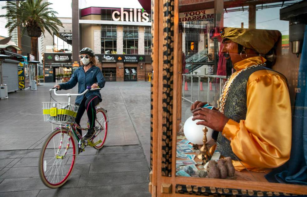 Jean Boccelli pedals past a Zoltar Fortune Teller machine near Chili's Grill & Bar along La ...