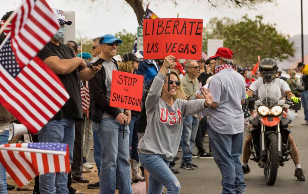 Protester Lauren Robison welcomes others arriving to the Reopen Nevada protest at the Grant Sa ...
