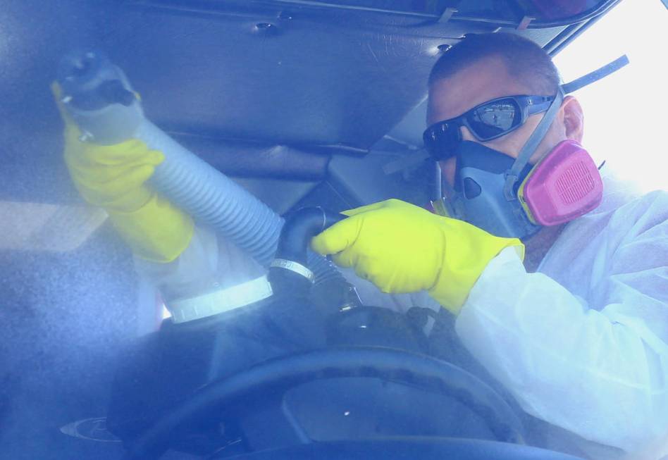 Travis Hoskins of Summit Restoration disinfects a Las Vegas Fire Department truck on Monday, Ap ...