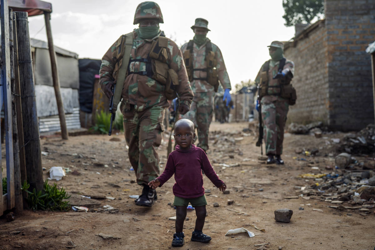 South African National Defense Forces patrol the Sjwetla informal settlement after pushing back ...