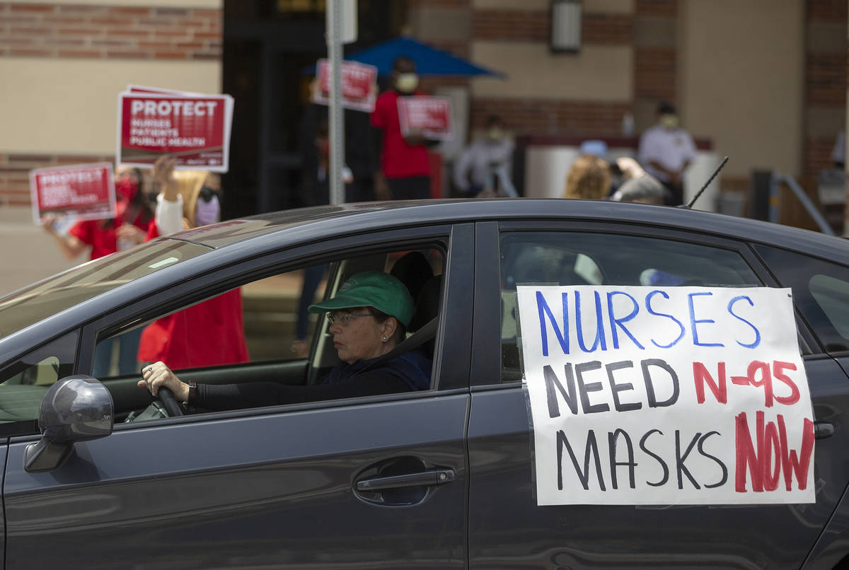 FILE - In this April 13, 2020, file photo, a car passes nurses protesting the lack of N95 respi ...