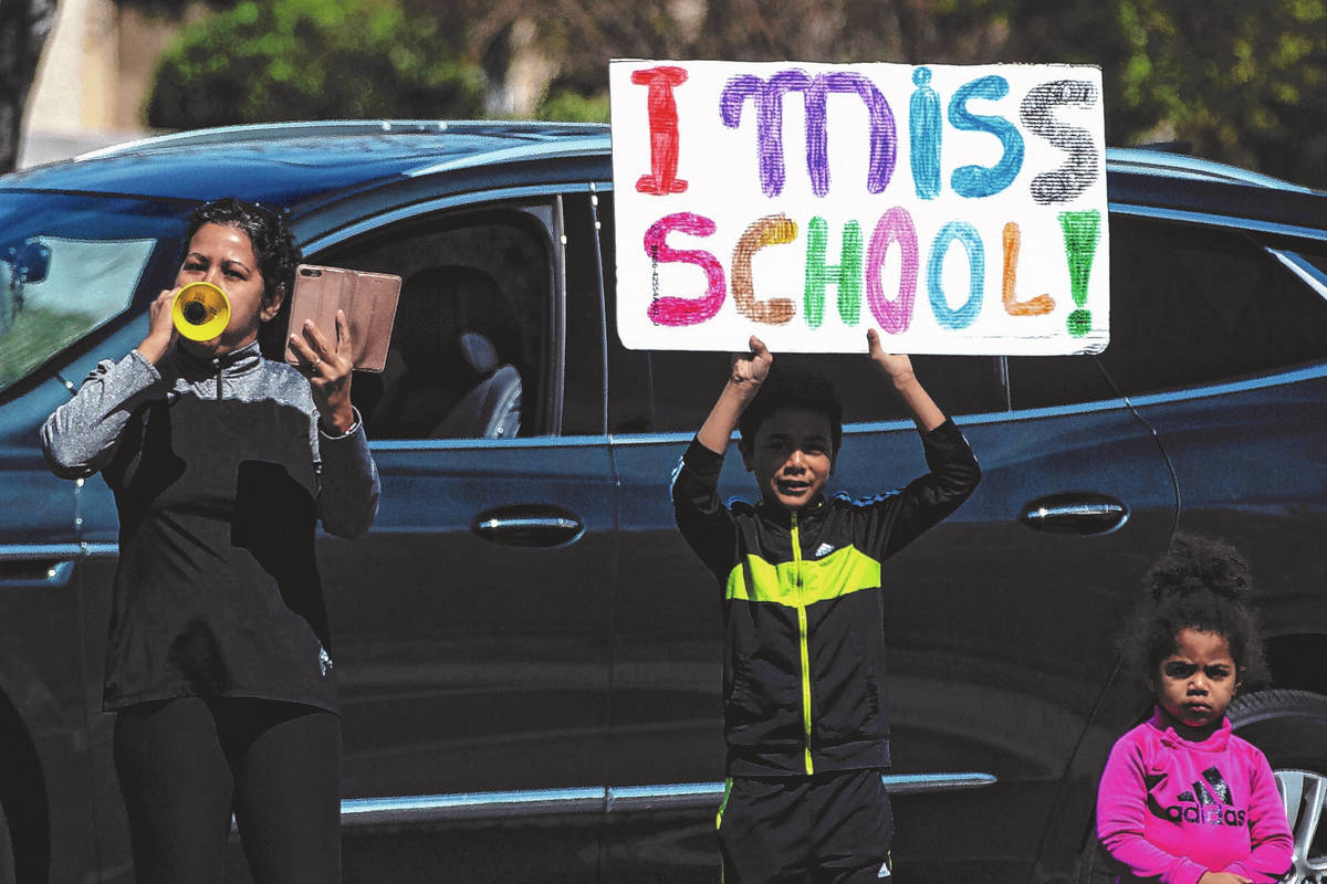 Las Vegas residents wave to teachers and staff from O’Roarke Elementary School who organ ...