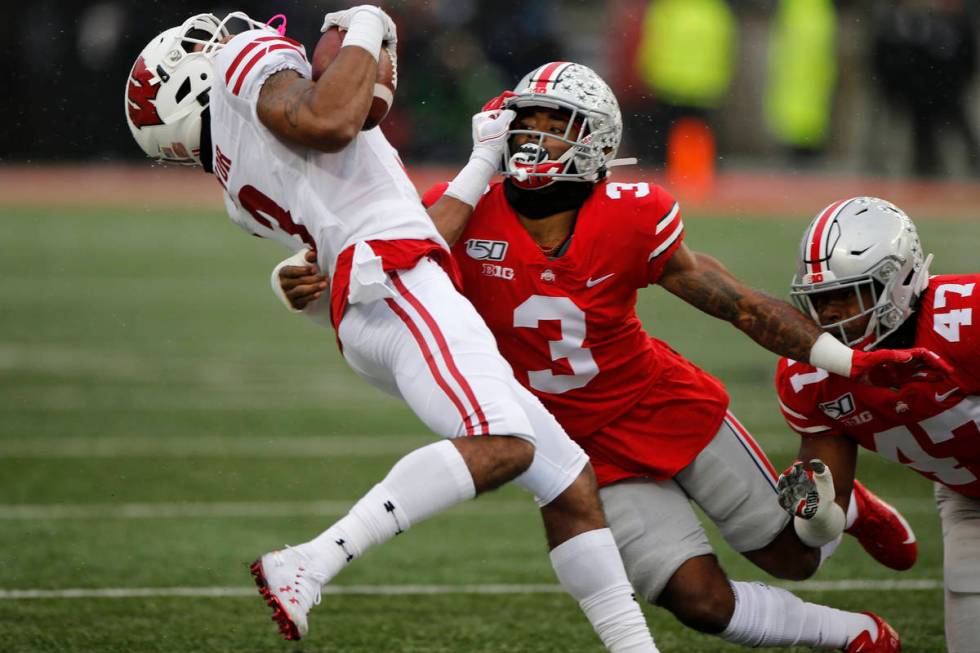 Ohio State defensive back Damon Arnette, right, tackles Wisconsin receiver Kendric Pryor during ...