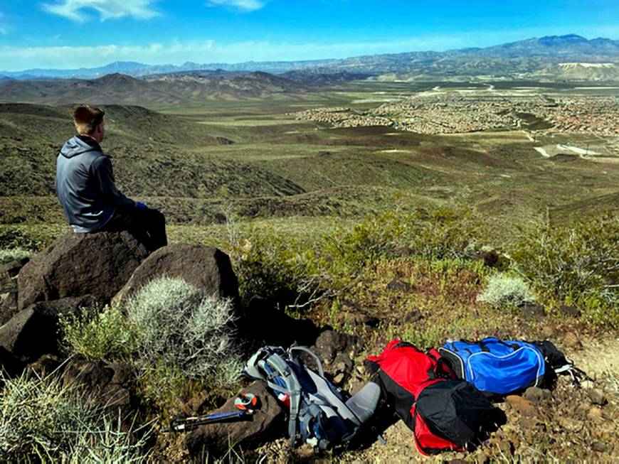 Mason Koch looks down to the Anthem area while atop of Black Mountain to adjust the heart shape ...