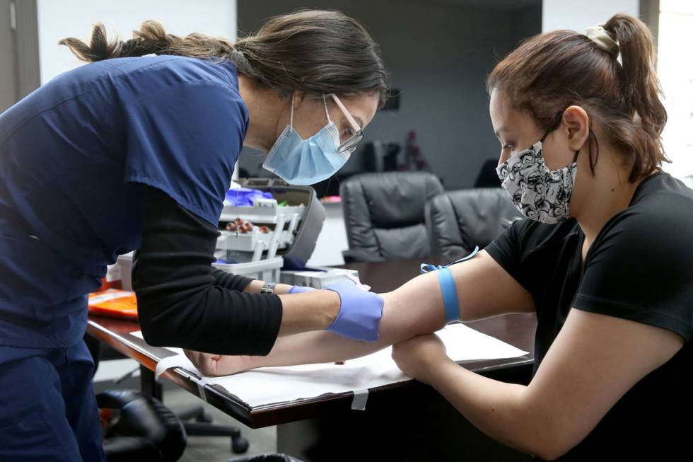 Jazmin Leyva, 28, a production technician at Designs for Health, receives voluntary COVID-19 an ...