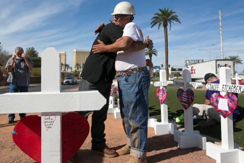 Cross maker Greg Zanis, right, gets a hug from Mike Warino, brother of Oct.1 shooting victim He ...