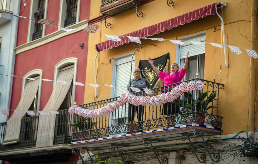 In this photo taken on Saturday April 25, 2020, a woman sings on her decorated balcony during t ...