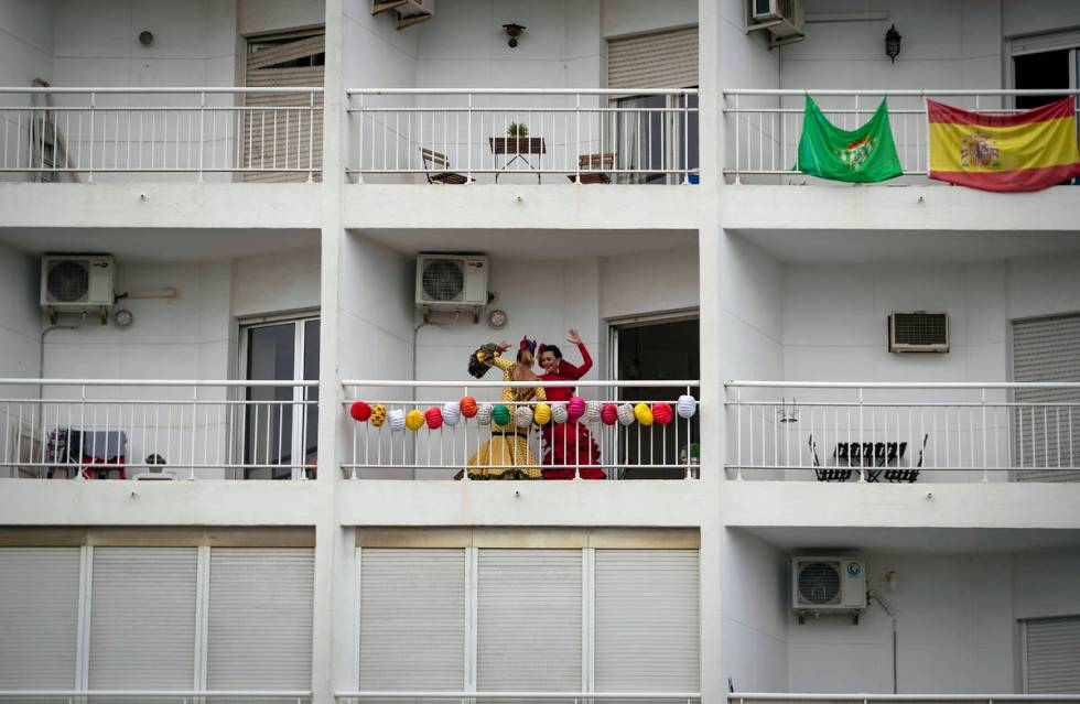 In this photo taken on Saturday April 25, 2020, two women dance on their decorated balcony duri ...