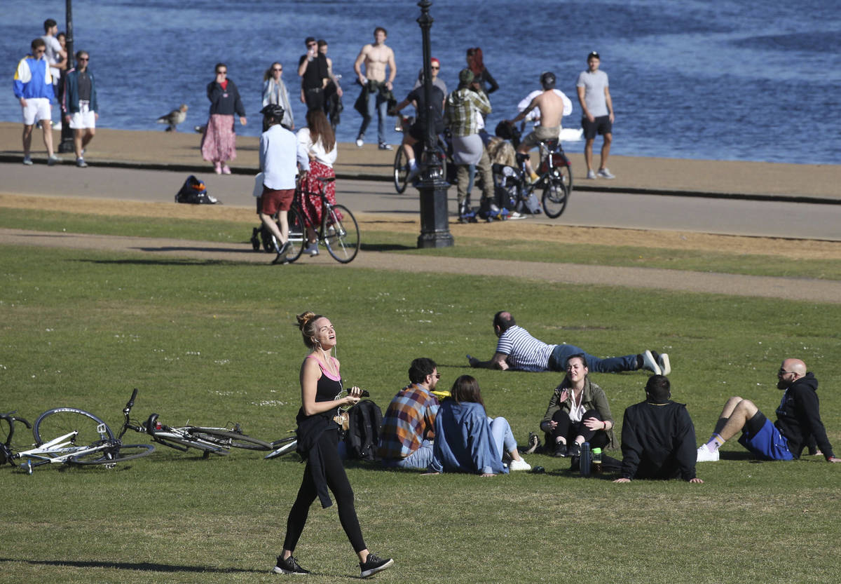 People walk, exercise and relax by the Serpentine in Hyde Park as the UK continues its lockdown ...