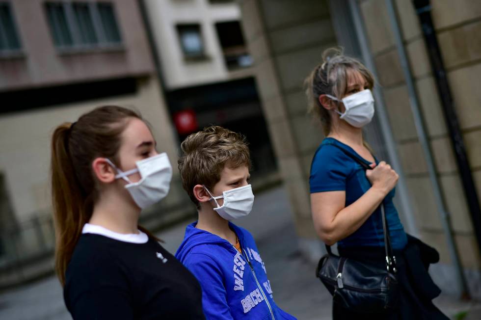 A family wearing face mask to protect of the coronavirus go for a walk, in Pamplona, northern S ...