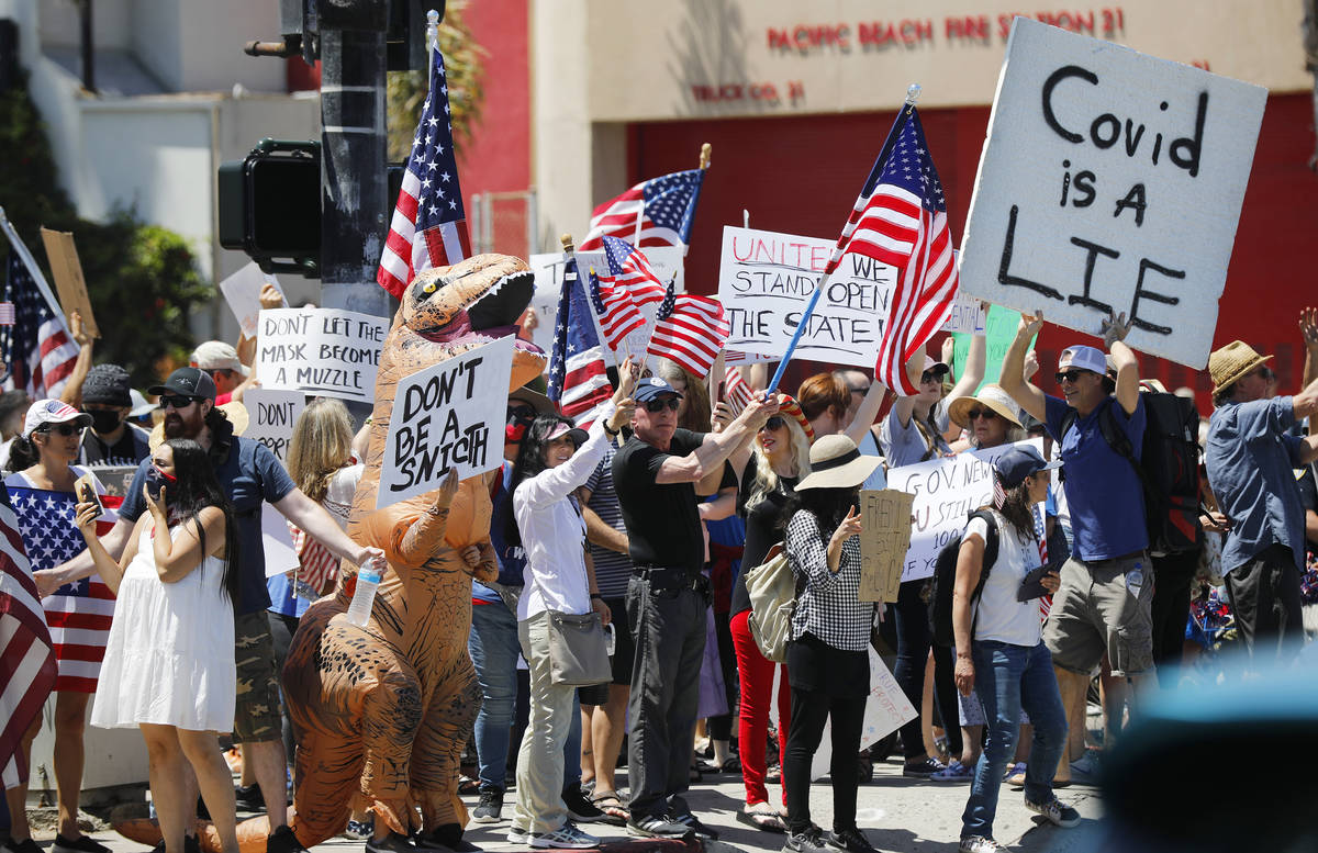 Protesters stand along Mission Blvd. during A Day of Liberty rally in Pacific Beach in San Dieg ...