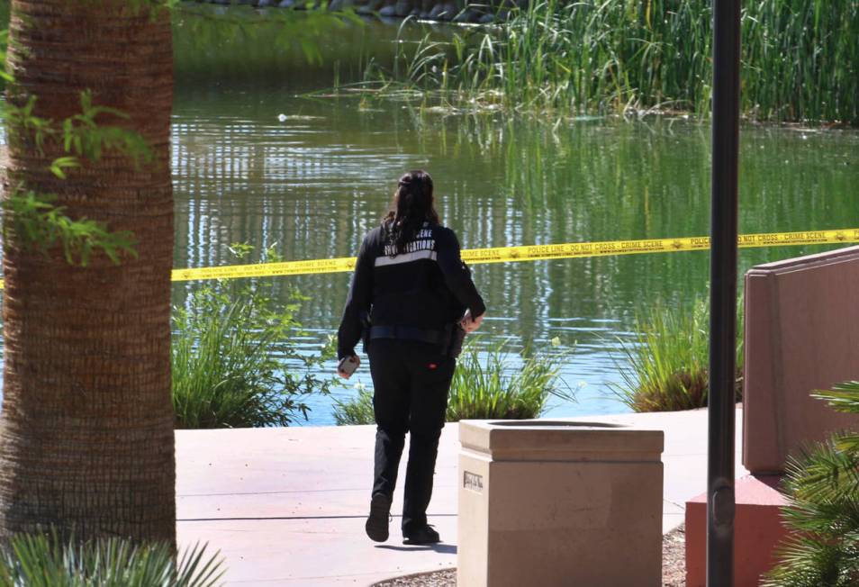 A Las Vegas police crime scene investigation officer works at the scene after a man's body was ...