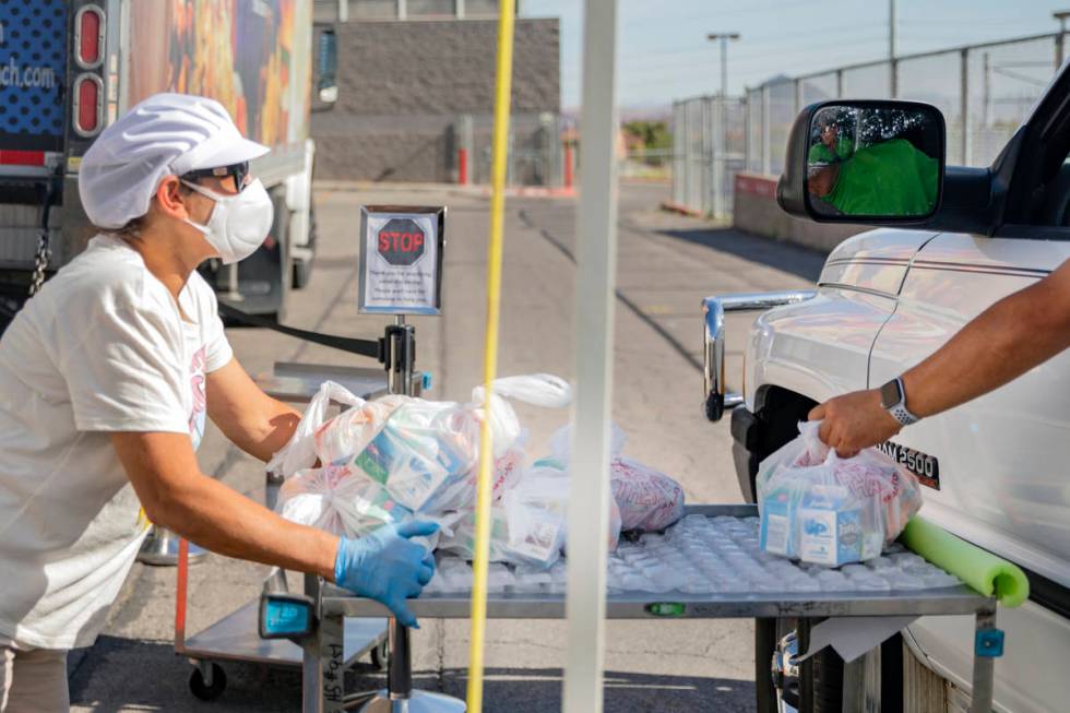 Food service manager of Basic Academy of International Studies, Yanina Cartellone, left, passes ...