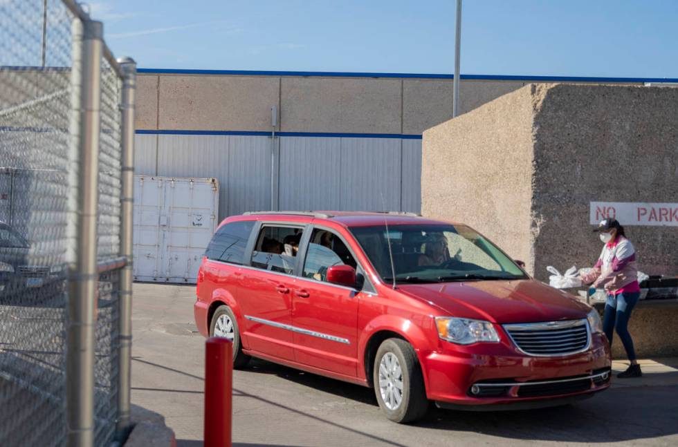 Individuals collect meals from Basic Academy of International Studies, a CCSD food distribution ...