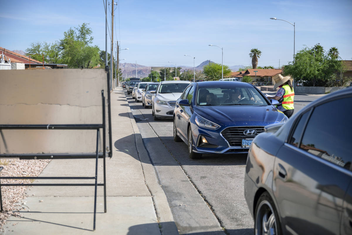 A line of cars stretching one mile down Palo Verde Drive wait to collect meals from St. Therese ...