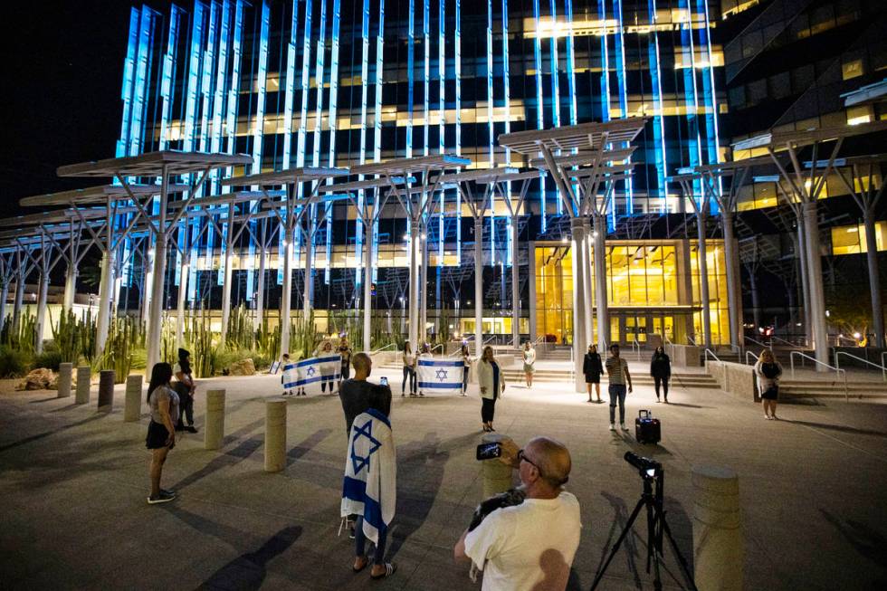 Gal Hayon, right, sings ""Hatikvah," the Israeli national anthem, as the flag of ...