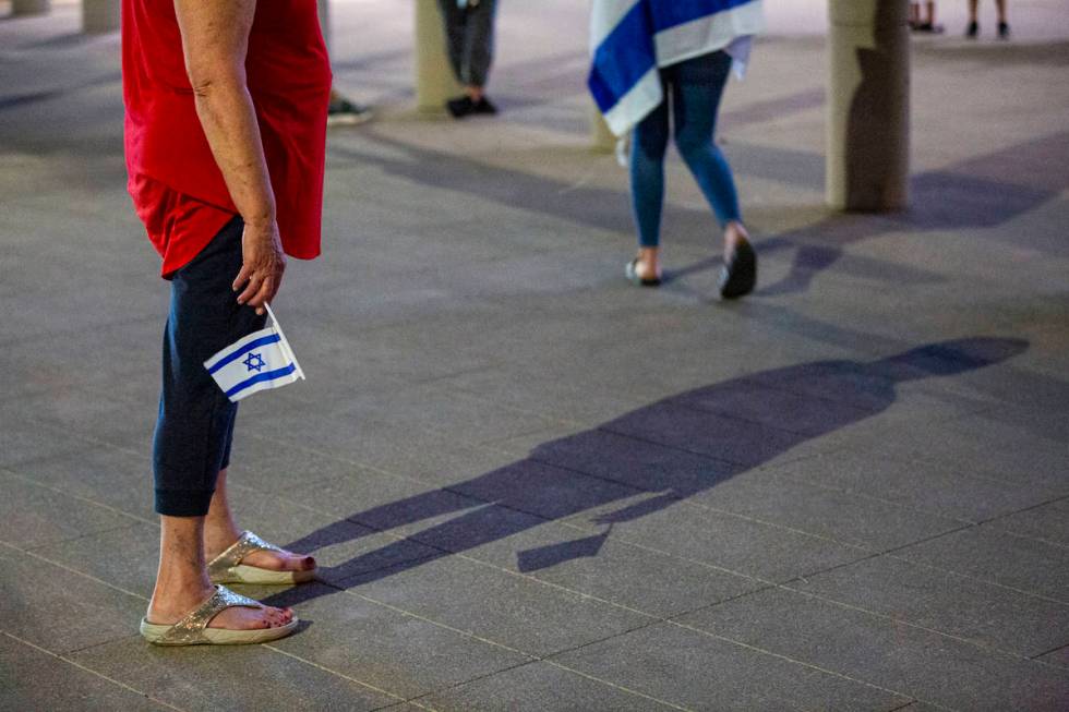 An attendee holds the Israeli flag while practicing social distancing as Gal Hayon, not picture ...