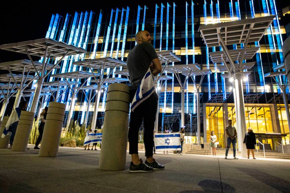 A man holds the flag of Israel as it is displayed at Las Vegas City Hall in honor of Israel's 7 ...