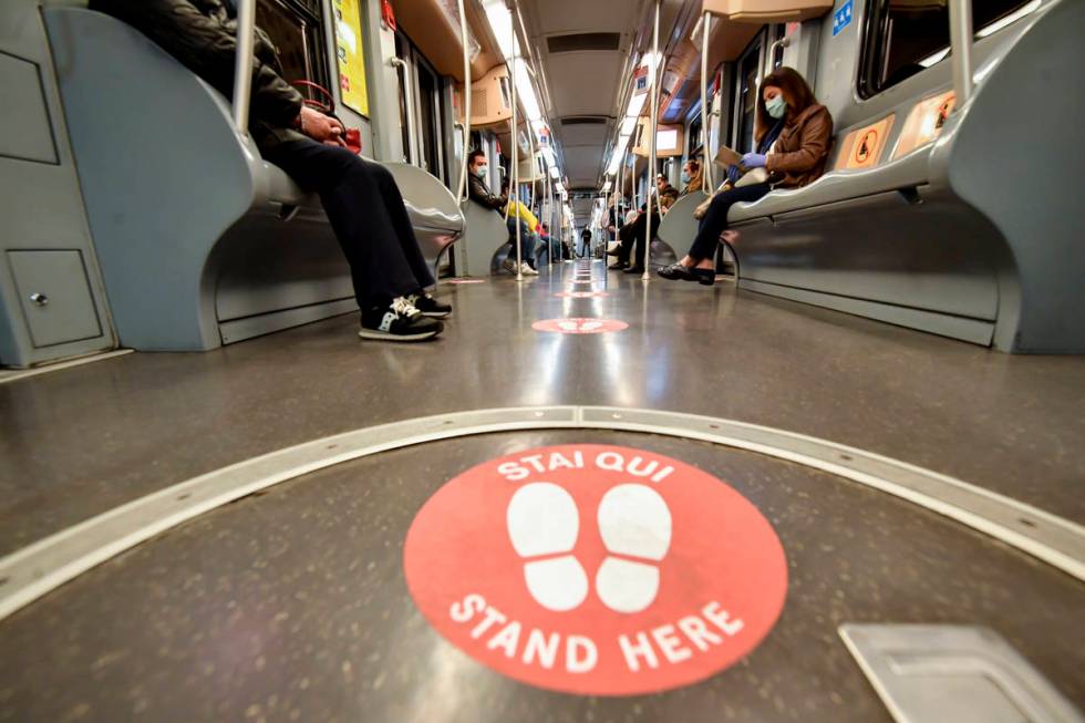 Passengers takes their seats apart from each other as red signs mark the right distances to kee ...