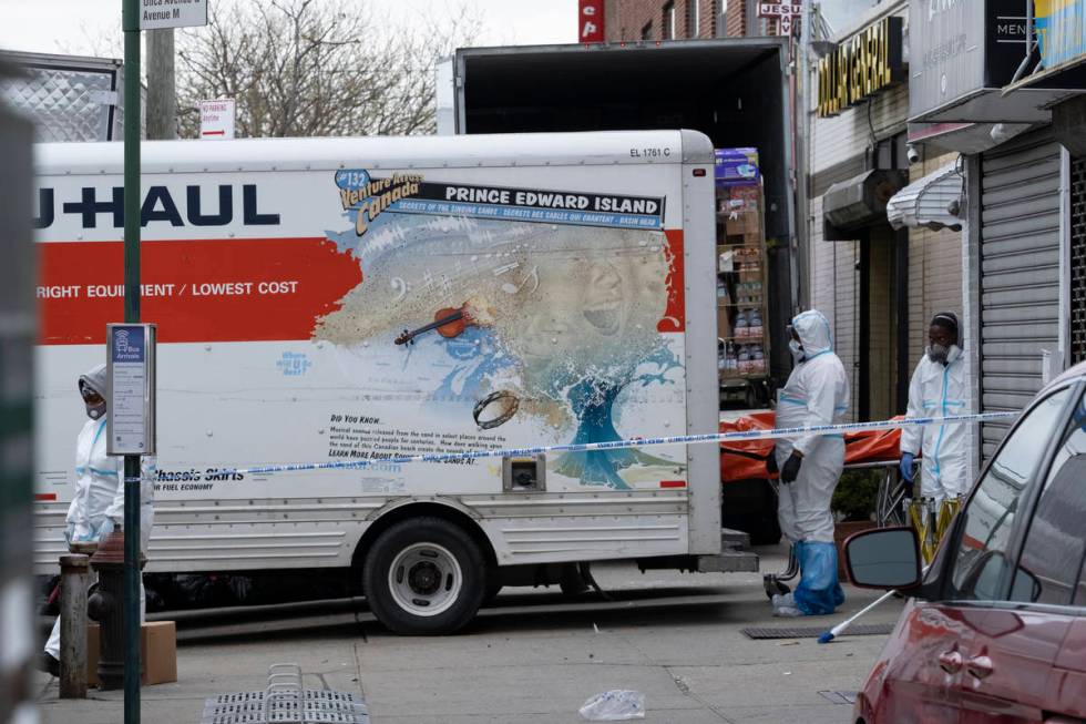 Workers move a body near the Andrew T. Cleckley Funeral Home in the Brooklyn borough of New Yor ...