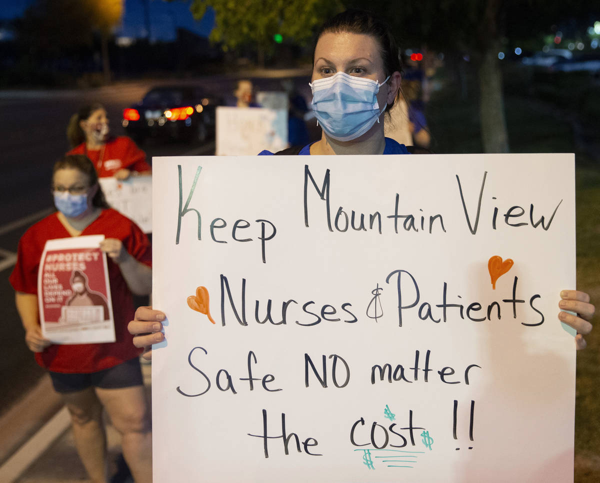 Emergency room nurse Nicole Harms holds a sign advocating for better protection, testing and be ...