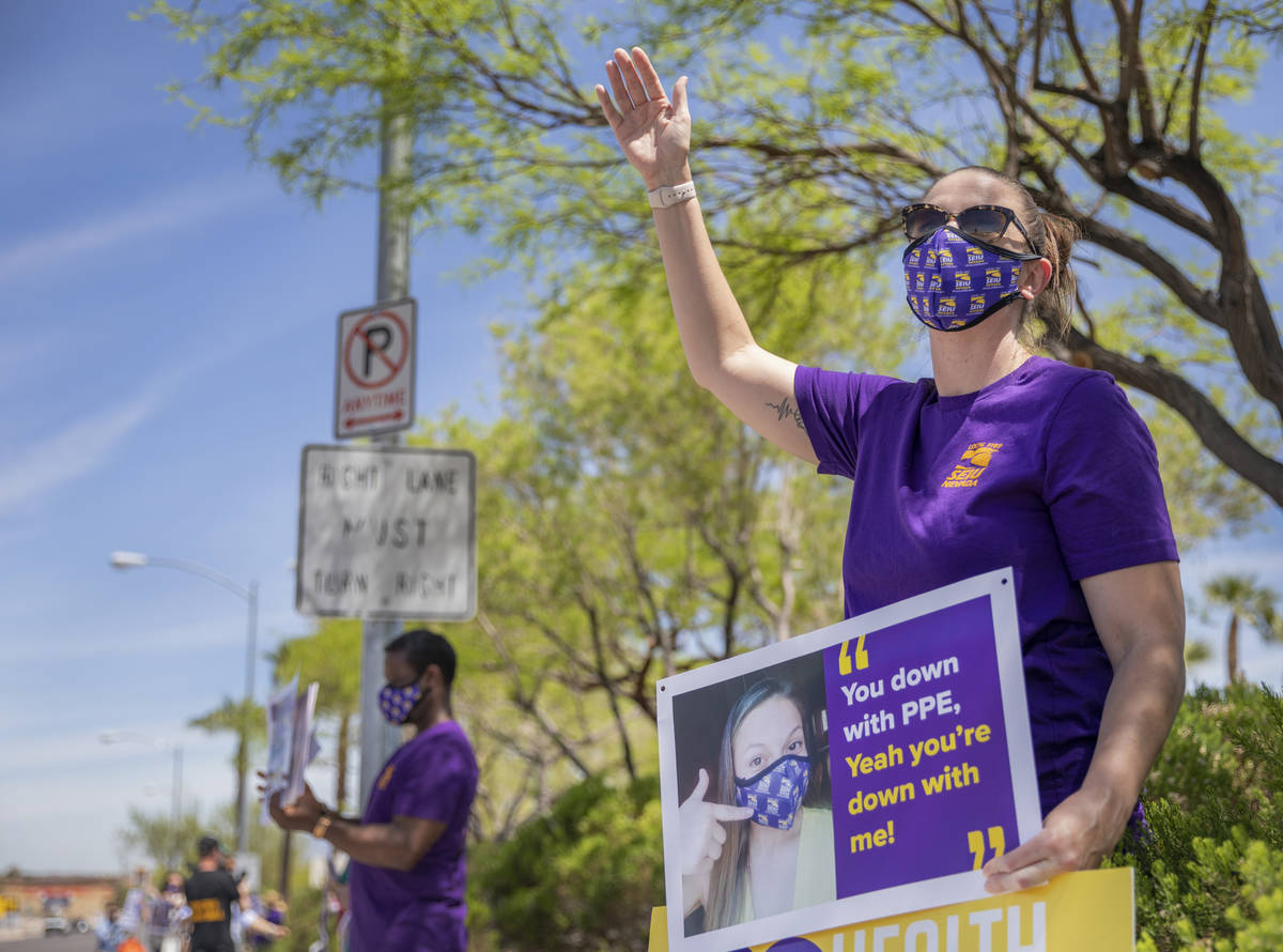 Jody Domineck, Local SEIU 1107 member, waves at cars that honk as Local SEIU members protest un ...