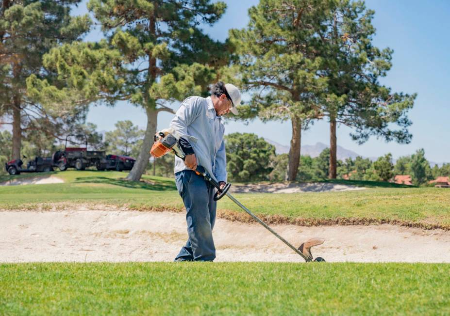 Groundskeeper Jose Gallegos edges the sand bunkers in preparetion for the opening of the Spanis ...