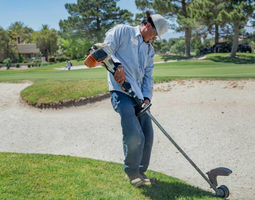 Groundskeeper Jose Gallegos edges the sand bunkers in preparetion for the opening of the Spanis ...