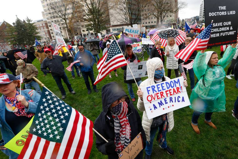 Protesters rally at the State Capitol in Lansing, Mich., Thursday, April 30, 2020. Hoisting Ame ...