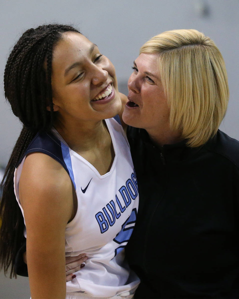 Centennial's Jade Thomas celebrates with an assistant coach after her shot at the buzzer forced ...