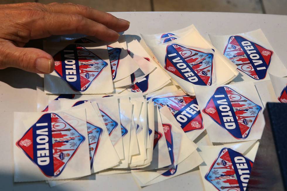 An election official, displays "I Voted" stickers at a polling station on Nov. 6, 2018, in Hend ...