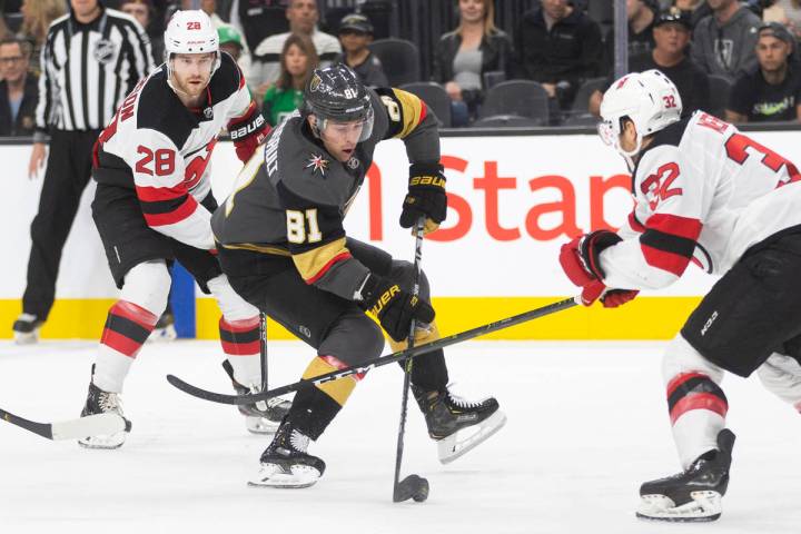 Vegas Golden Knights center Jonathan Marchessault (81) tries to skate around New Jersey Devils ...