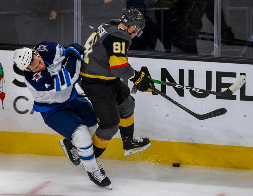 Winnipeg Jets defenseman Neal Pionk (4) collides with Vegas Golden Knights center Jonathan Marc ...