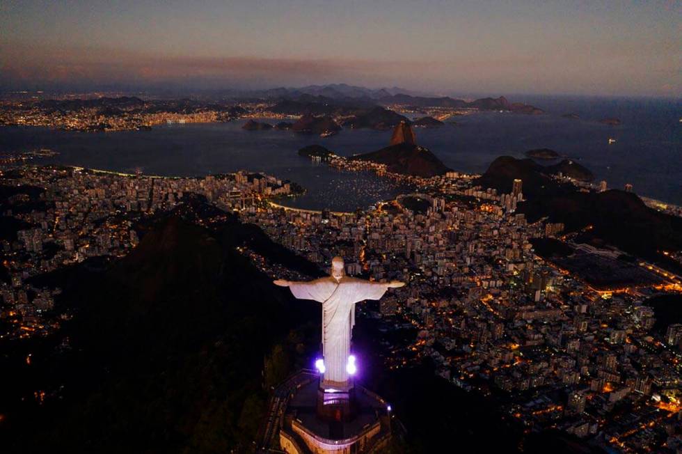 The Christ the Redeemer statue stands above the Guanabara bay during dusk amid the outbreak of ...