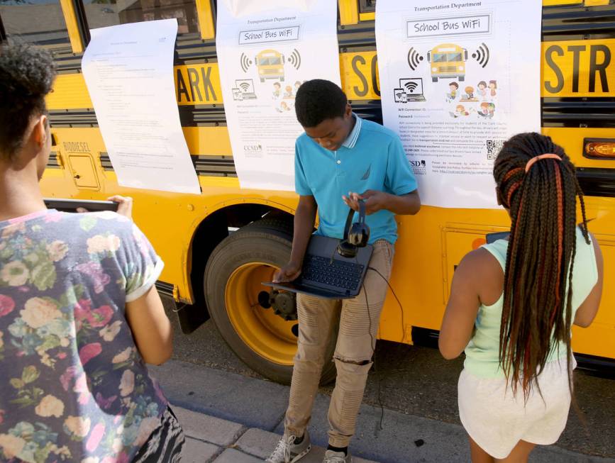 Damien Speed, 13, works on homework with his sisters Jaliyah Speed, 14, left, and Malaya Speed, ...