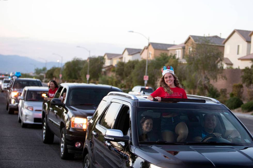 Senior Gracelyn Gattis smiles out her sunroof as a parade of cars pass Coronado High School for ...