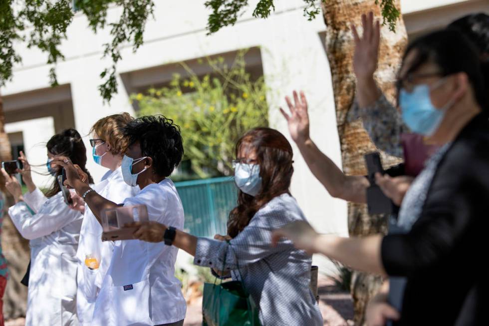 Southwest Medical physicians and nurses wave to a parade of vehicles who drove through to suppo ...