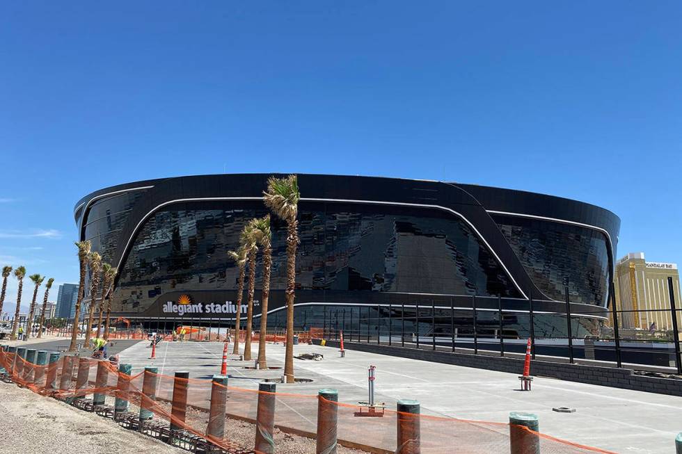 Workers carry out sidewalk pouring and landscaping work on Allegiant Stadium on Friday, May 1, ...