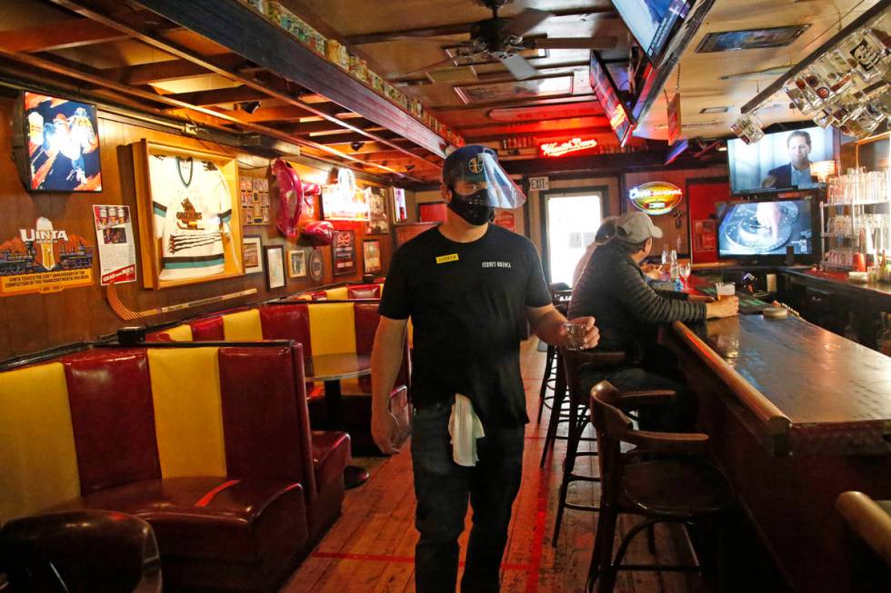 Cheers to You bartender Andrew Lohry wears a mask and face shield after the bar opened Friday m ...