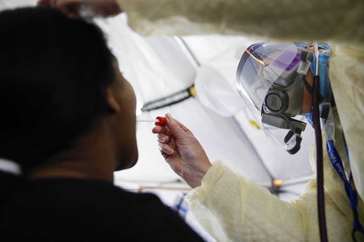 In this April 20, 2020, photo, a test is performed on a patient in a COVID-19 triage tent at St ...